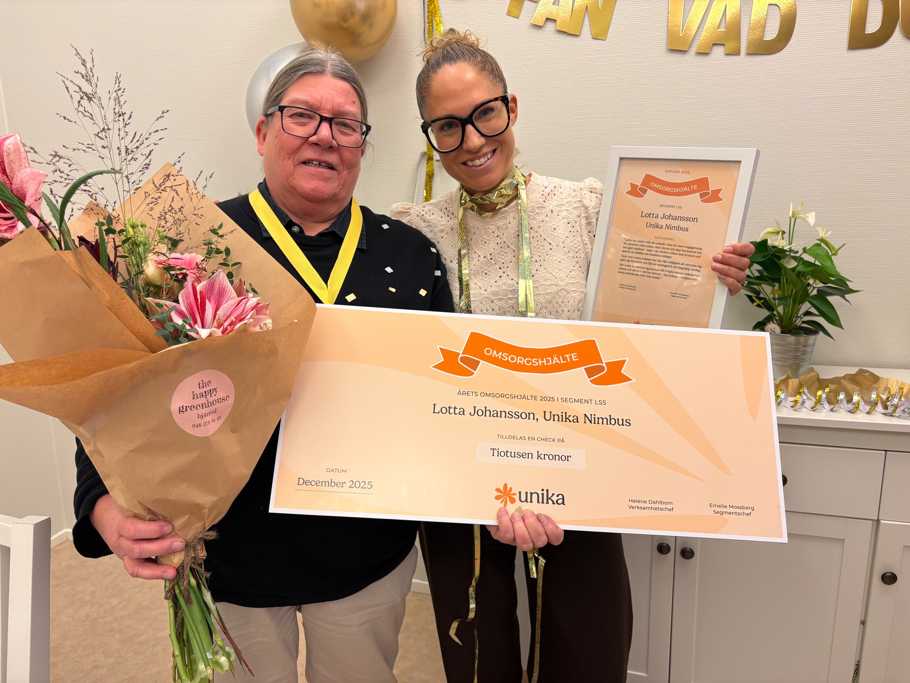 Lotta Johansson, med blommor, en stor check och i sällskap av segmentschef Emelie Mossberg