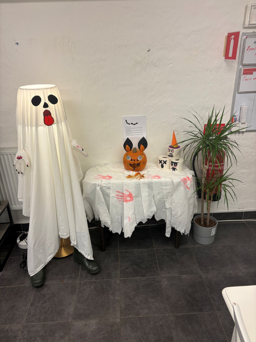 En lampa omgjord till sp&ouml;ke, p&aring; bord bredvid l&auml;skigt utkarvad pumpa som ser ut som l&auml;skig kanin. Sp&aring;r av blodiga h&auml;nder p&aring; duken.