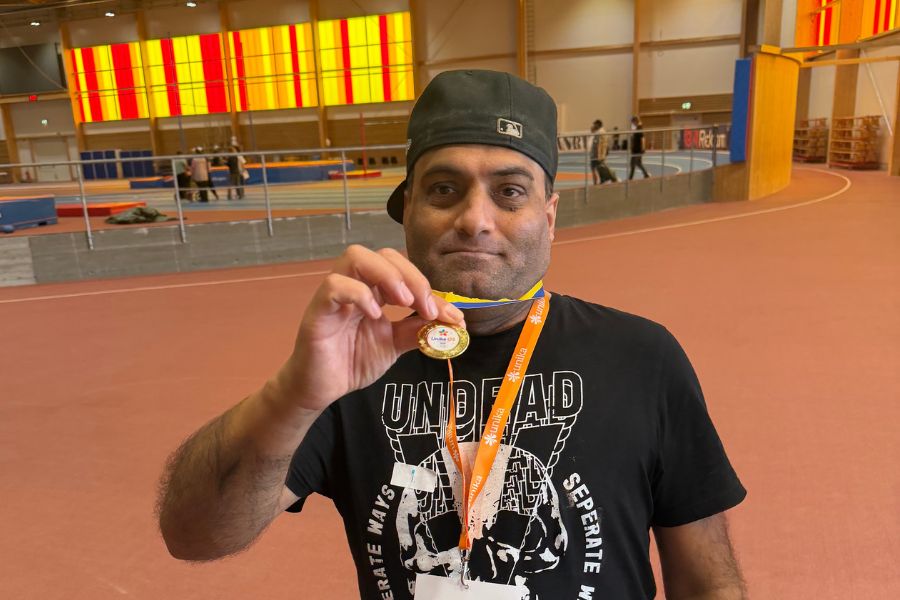 En glad deltagare visar stolt upp sin medalj