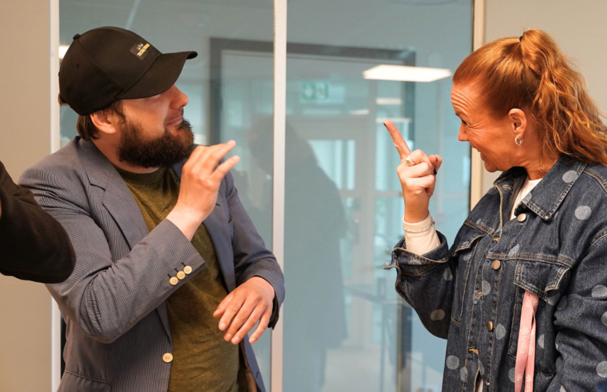Oleg och Linnea som arbetar p&aring; Unika Bergshamra pratar teckenspr&aring;k med varandra