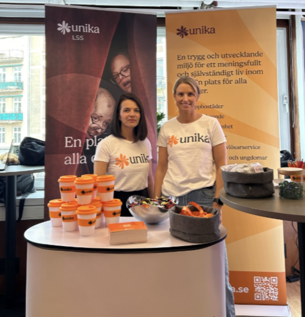 Personal från unika står i unikas monter på mässa.